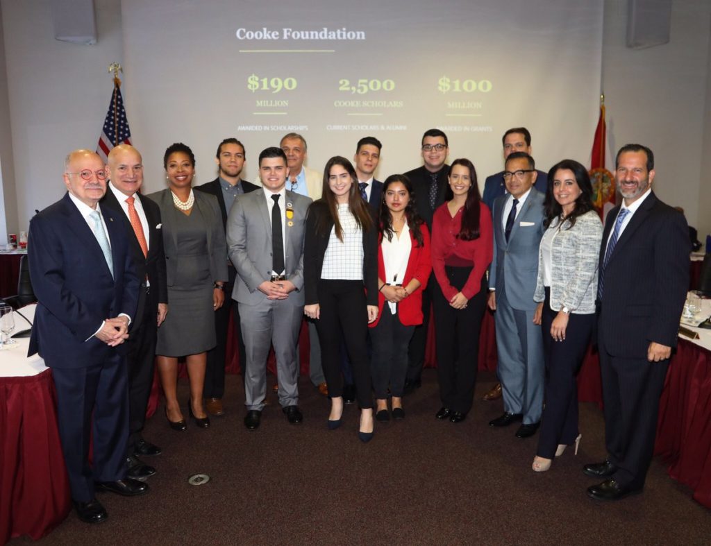 Executive Director Seppy Basili, Miami Dade College President Eduardo J. Padrón, and other leaders at the college surprise seven students with news of their Cooke Undergraduate Transfer Scholarship award.