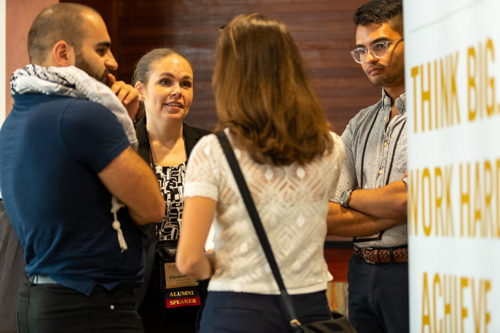 Four Cooke Scholars stand in a circle engaged in conversation.